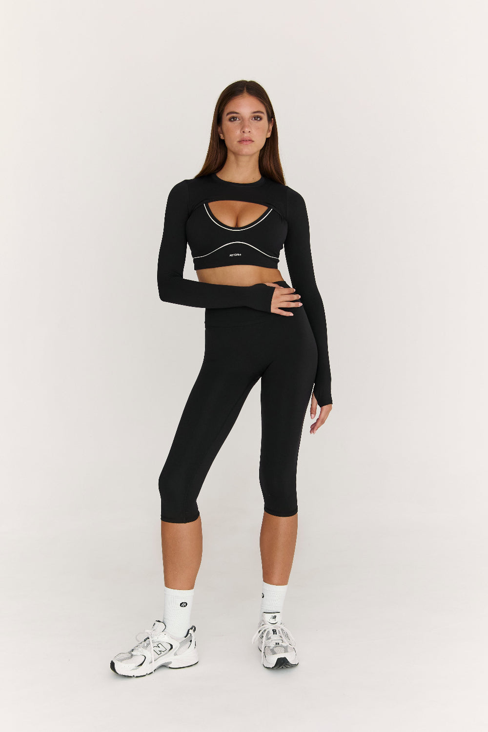 Woman wearing a black athletic outfit on a white background