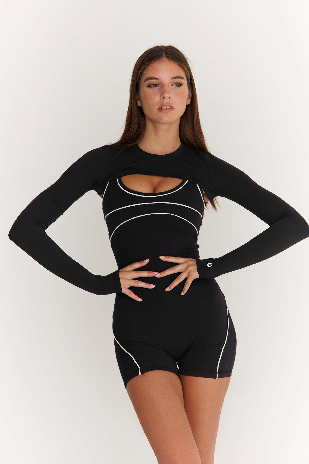 Woman wearing a black athletic outfit with white accents on a white background