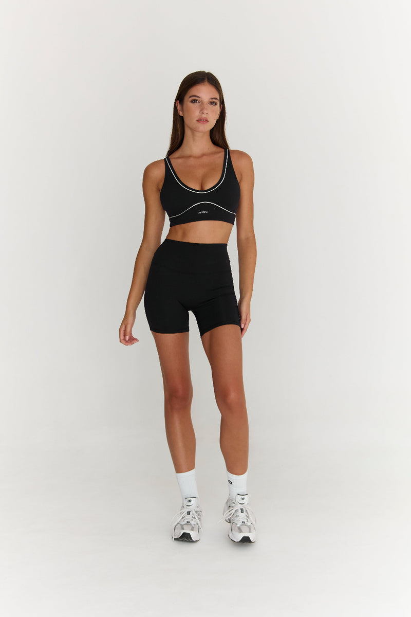 Woman wearing a black athletic outfit on a white background